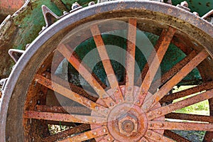 Rusty spokes of a wheel on an antique tractor