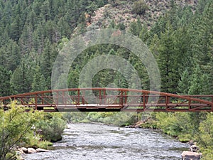 A rusty steel bridge over a creek