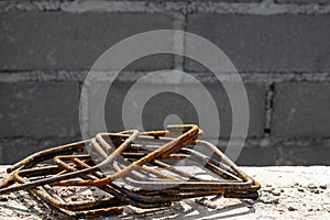 Rusty steel rebar scraps. Stack of rust.y iron rods or bars on the background of a concrete wall