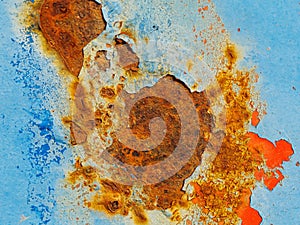 Rusty surface of metal plate with blue cracked color paint.