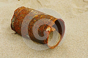 Rusty tin can on beach