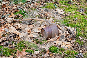 A rusty tin can thrown out in the forest. The concept of environmental pollution