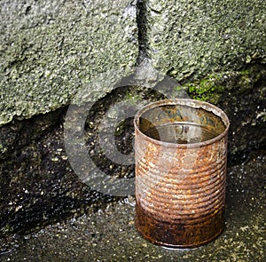 Rusty tin can with water