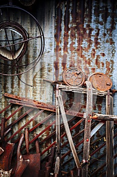 Rusty tools leaning against corrugated metal wall