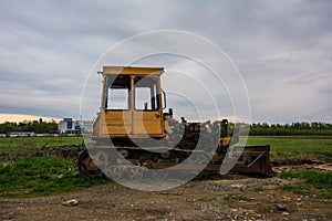 Rusty tractor on tracks in the field