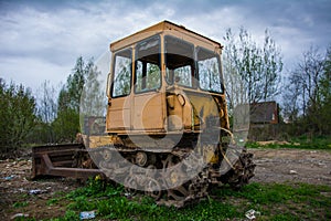 Rusty tractor on tracks in the field