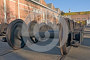 Train wheel sets in front of an industrial building