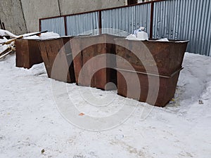 Rusty trash cans on the snow in winter