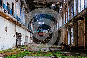 Rusty turbine generator. Abandoned destroyed by war and overgrown by plants and moss machinery of Tkvarcheli Tquarchal power plant