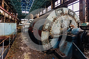 Rusty turbine generator. Abandoned destroyed by war and overgrown by plants and moss machinery of Tkvarcheli Tquarchal power plant