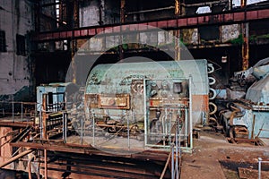 Rusty turbine generator. Abandoned destroyed by war and overgrown by plants and moss machinery of Tkvarcheli Tquarchal power plant