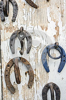 Rusty upside down horseshoes on wood panel