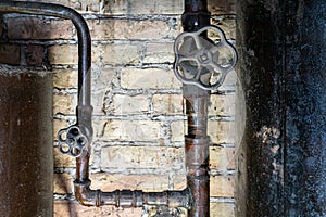 Rusty valves on boiler room pipes. Old metal boiler generating heating and delivering it to home through pipeline