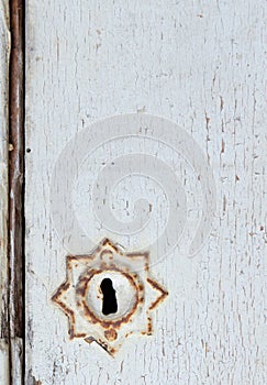 Rusty vintage lock on a white rustic door