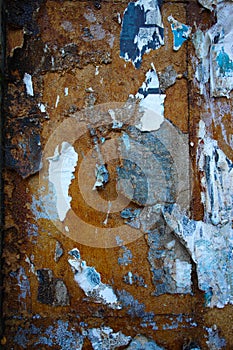 Rusty wall with peeling paint and torn paper