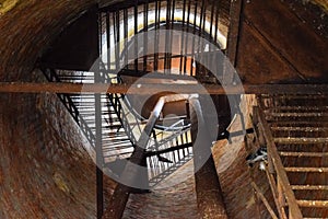 Rusty water tower inside view from top to bottom. Old water pump. Ladder to water tank, pigeon droppings