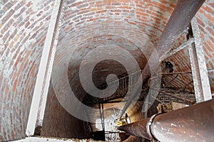 Rusty water tower inside view from top to bottom. Old water pump. Ladder to water tank, pigeon droppings