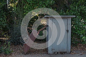 Rusty wheel Barrow with a cute little white tool shed