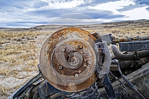 The rusty wheel and brake on an overturned SUV in the Nevada desert, USA