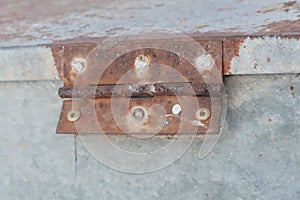 Rusty white metal gate with door hinge