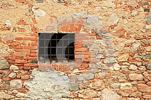 Rusty window grille and old brick wall