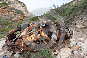 A rusty wrecked car on the beach