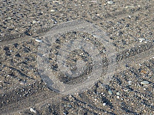 Rut in the sand. Tracks from car wheels on the beach. Sand and stones