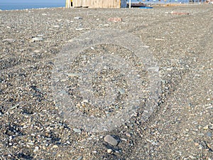 Rut in the sand. Tracks from car wheels on the beach. Sand and stones