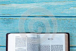 Ruth open Holy Bible Book on a wooden background with copy space