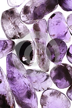 Rutilated amethyst jewel heap texture on light surface.