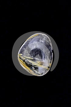 Rutilated quartz stone texture on black background. Macro closeup