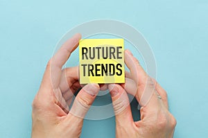 Ruture Trends text on yellow with pen on a sticker in hands and blue background.