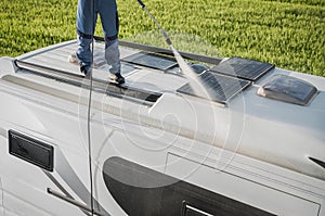 RV Industry Worker Cleaning Camper Van Roof and Motorhome Solar Panels