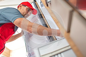 RV Technician Looking Inside Camper Refrigerator