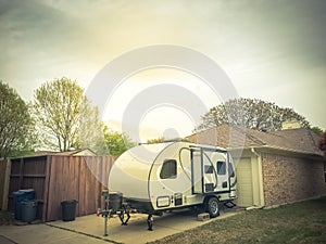 RV trailer parked at backyard of single family house, side view