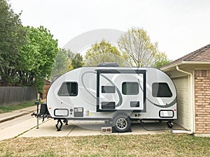 RV trailer parked at backyard of single family house, side view