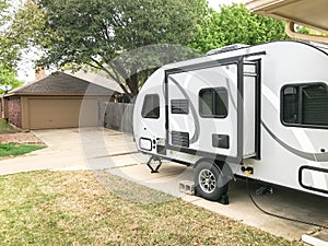 RV trailer parked at backyard of single family house, side view