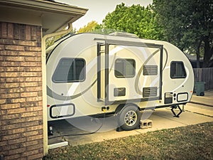 RV trailer parked at backyard of single family house, side view