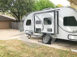 RV trailer parked at backyard of single family house, side view