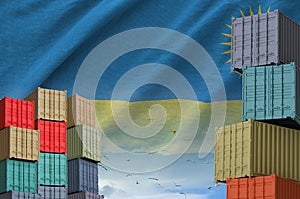 Rwanda flag and big stack of shipping cargo containers in docks with sky background photo