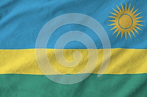 Rwanda flag depicted on folded wavy fabric of old cloth photo
