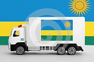 Rwanda flag depicted on side wall of white delivery van. Shipping and local delivery concept photo