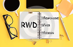 RWD - responsive web design, text on notepad and office accessories on yellow desk