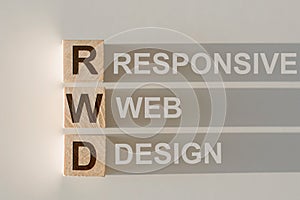 RWD - responsive web design, text on three wooden cubes on light gray background