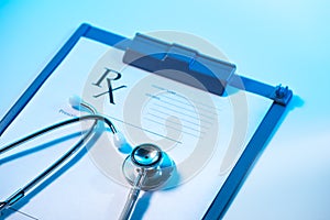 RX prescription form and stethoscope on stainless