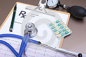 RX prescription, Red heart, pills, blood pressure meter and a stethoscope on table.