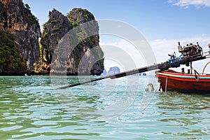 Rya Hang Yao. DIY engine and screw remote drive motor of long tail boat in the water. Mountains in the background and blue sky at