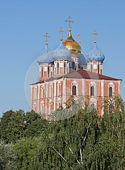 Ryazan, Russia. The Cathedral of the Dormition Uspensky Cathedral in the Kremlin in the greenery on the background blue sky