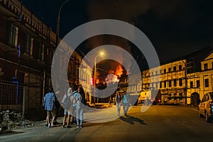 Rybinsk, Russia -31 July 2018 : Large night fire, burning modern building, smoke clouds, flames, people on street watching fire