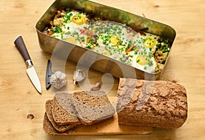 Rye bread, baked mixed vegetables and eggs close view, baking tray with tomatoes, broccoli and spices, home cooking